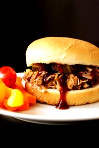1 Sandwich Pork Sandwich with Onions, Dill Pickles and Barbecue Sauce on White Roll