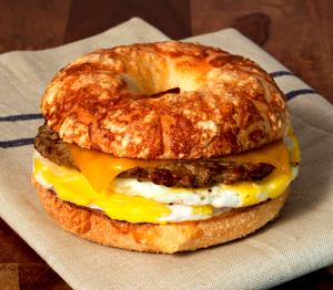 1 Serving Sausage, Egg And Cheddar On Asiago Bagel Sandwich